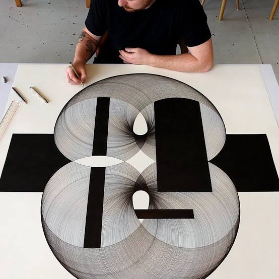 Overhead view of Peter Yuill working on a large-format geometric ink drawing