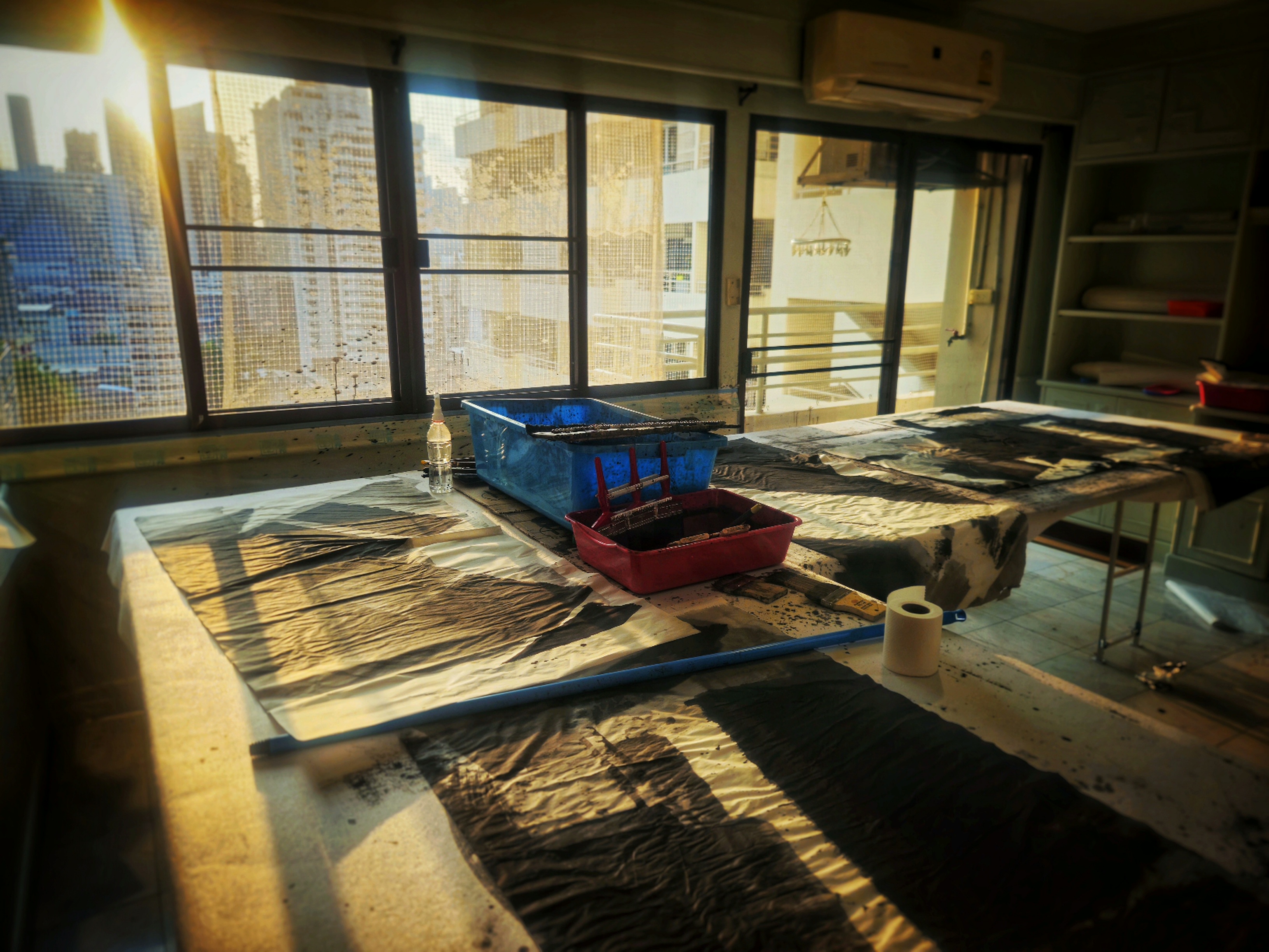 Bangkok studio — backlit window, work table, blasted afternoon light